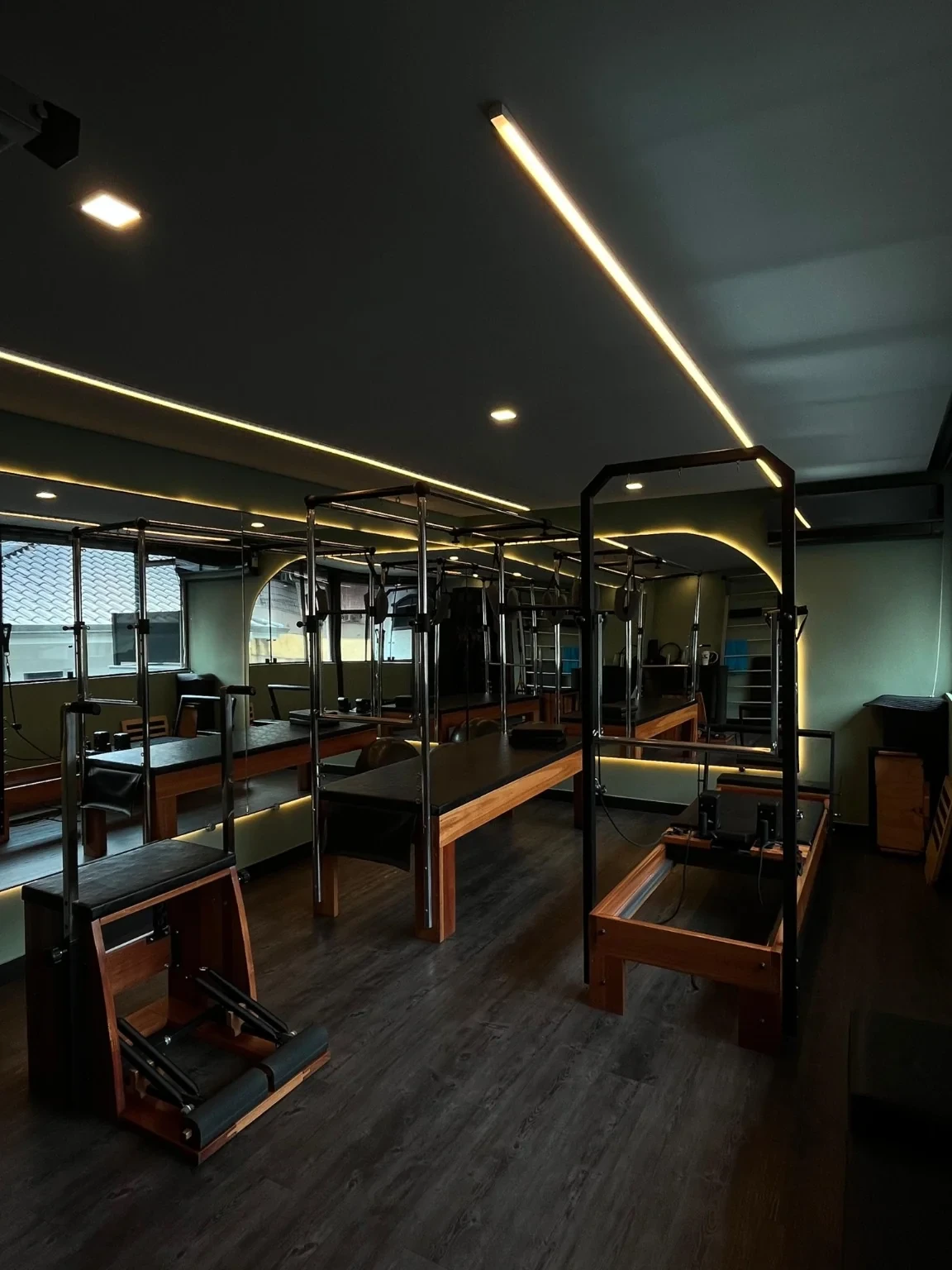Sala de Pilates da Personal Fire, com aparelhos de madeira e espelhos, sem alunos.